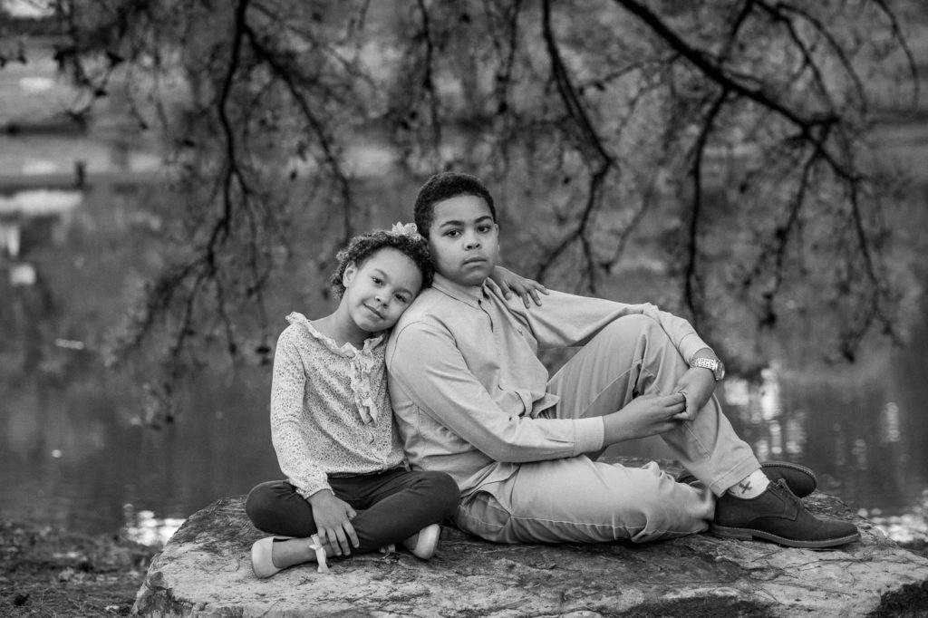 brother and sister posing on a rock