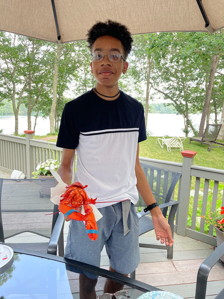 Teen boy holding a boiled lobster