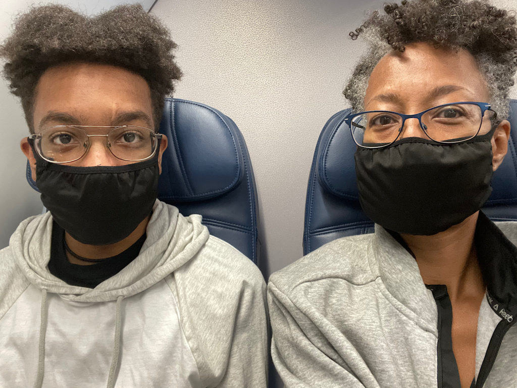 Mother and son wearing mask on airplane