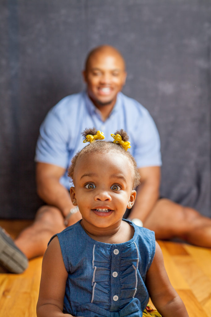 Toddler and her father sitting on the floor