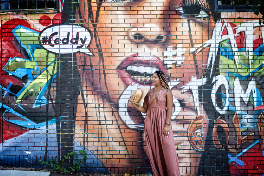 woman posing in front of a mural